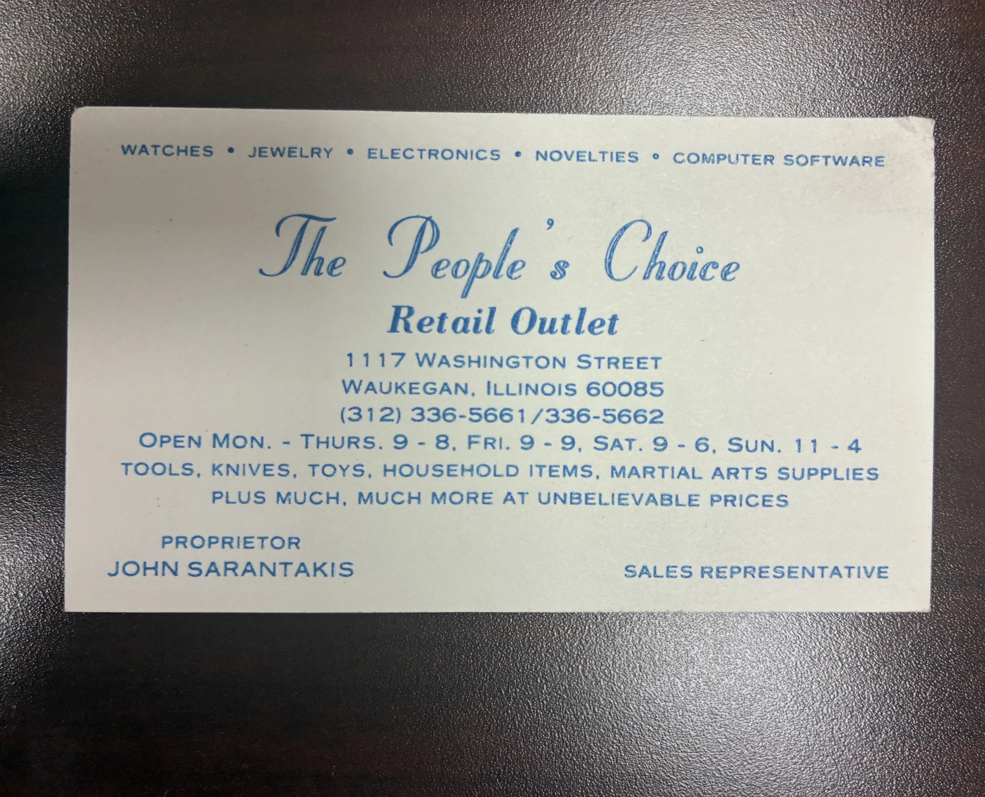 The 1983 People’s Choice Retail Outlet business card listing 1117 Washington Street, Waukegan, and John Sarantakis as proprietor.