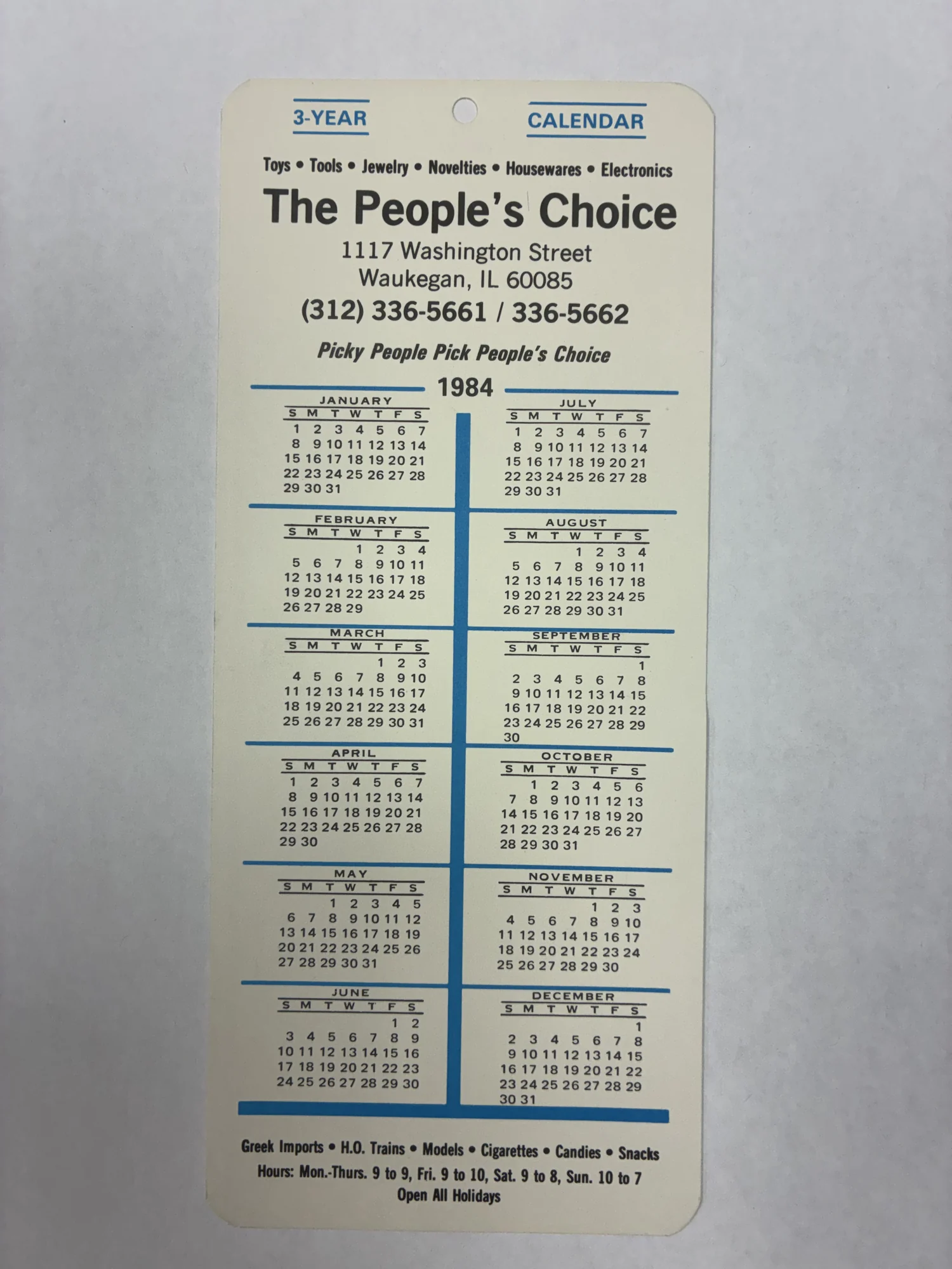 A 1984 People’s Choice three-year pass-out calendar card listing the 1117 Washington Street address, phone numbers, and store hours.