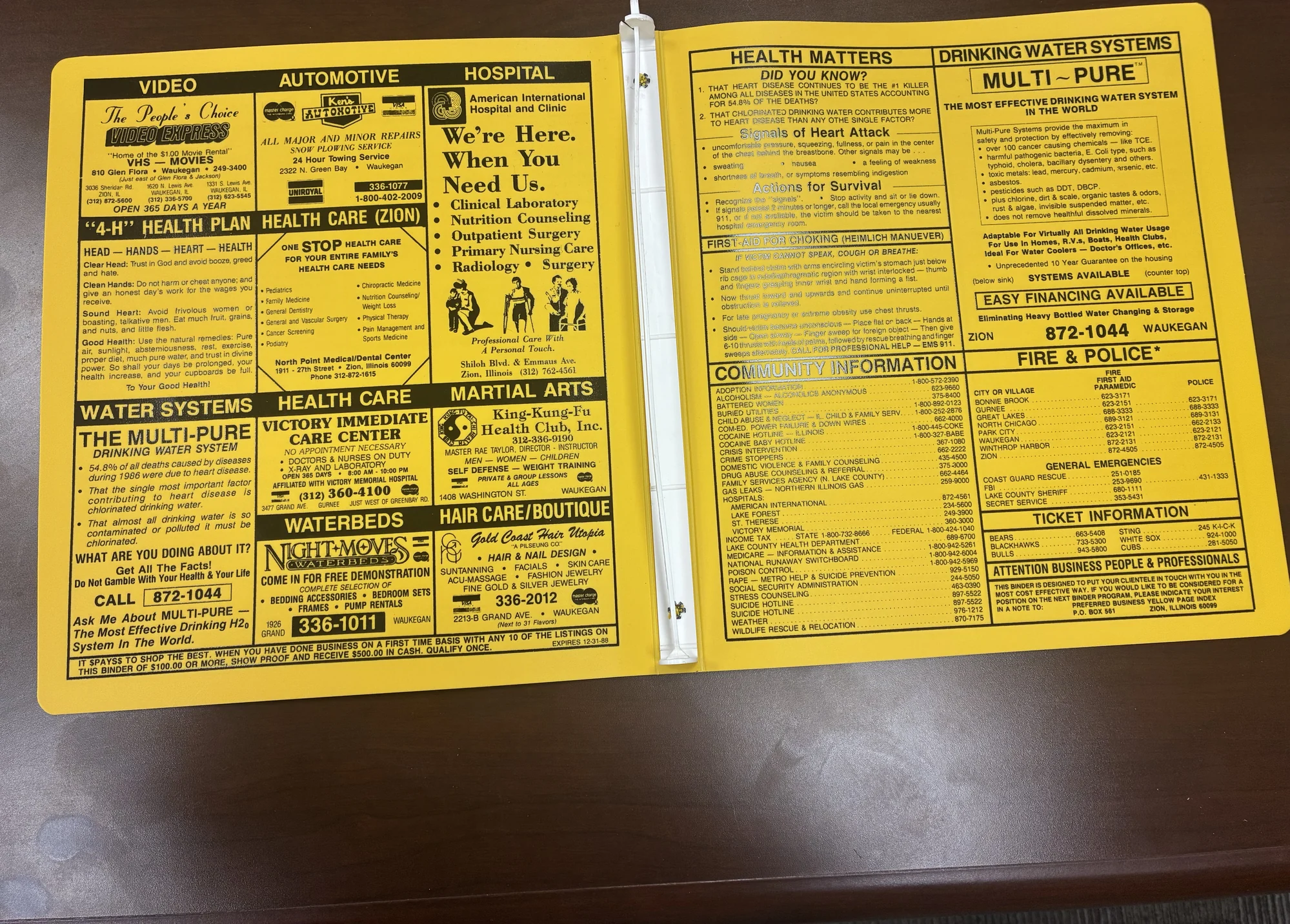 The open yellow 1987-88 telephone directory binder showing The People’s Choice advertisement among community listings.