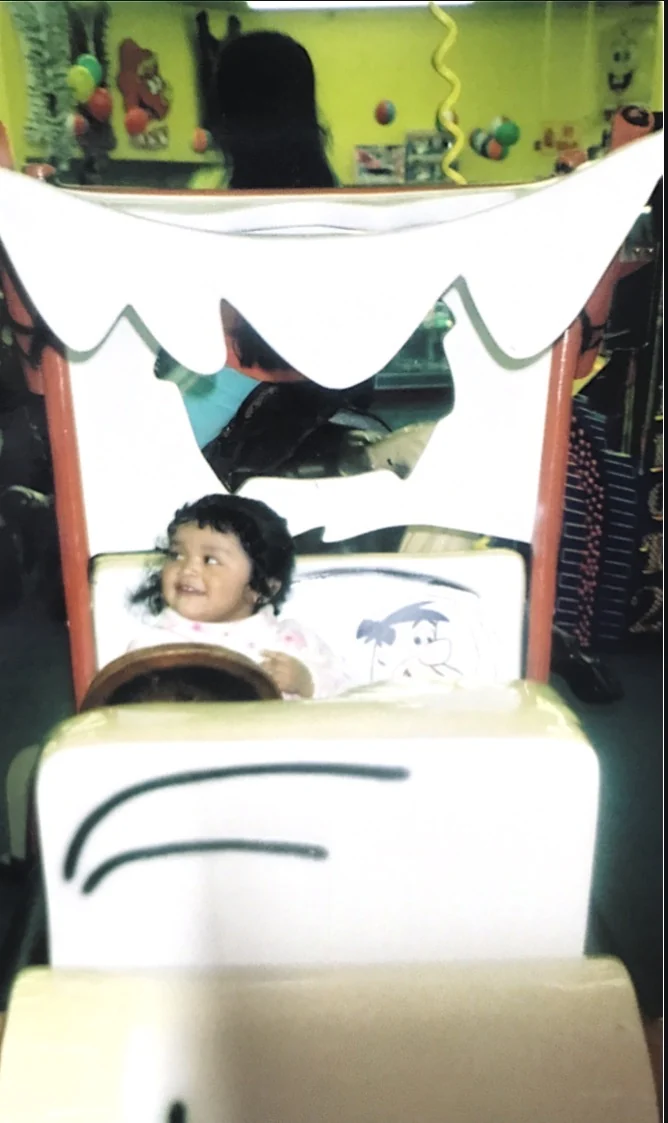 A little girl smiles from the seat of the Flintstones car ride at People’s Choice Family Fun Center in 2005.