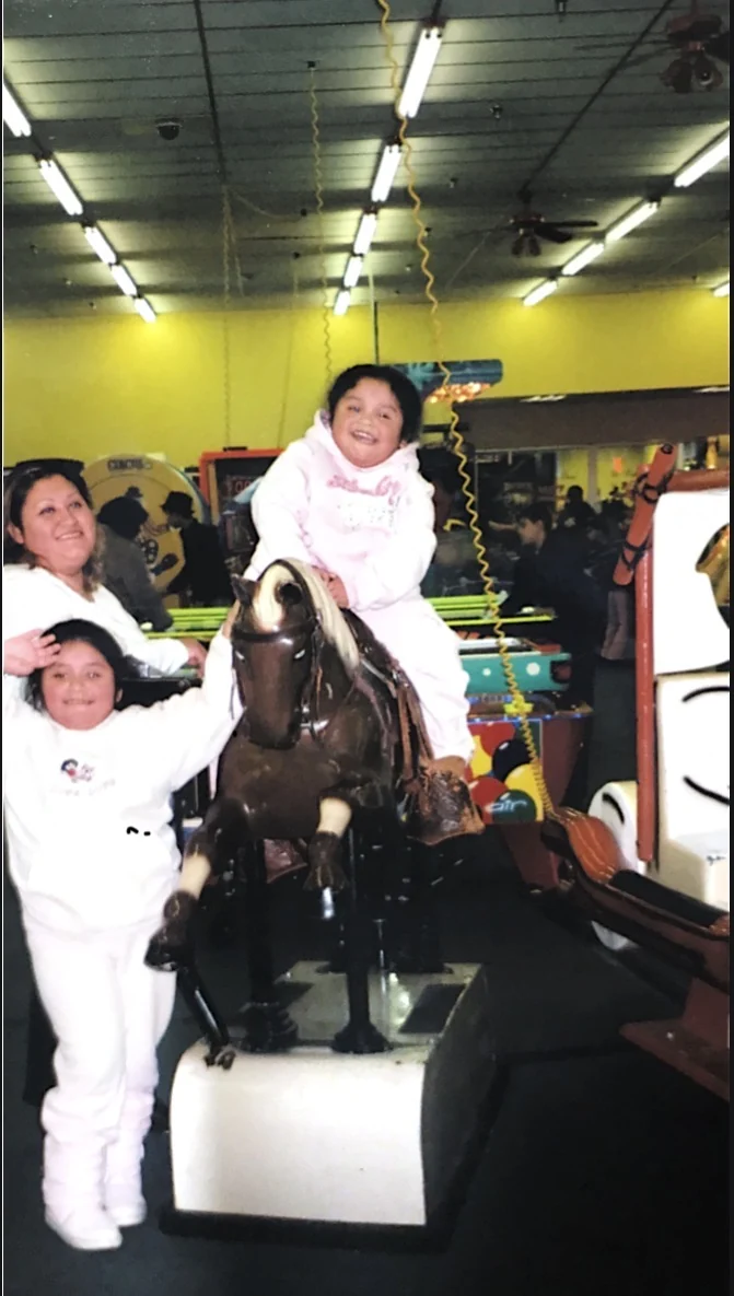 A girl rides the mechanical horse while her mother and sister stand beside her on the People’s Choice arcade floor in 2006.