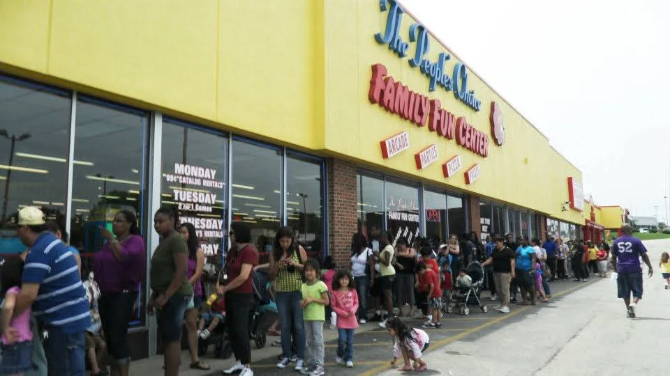 Families lined up along the sidewalk outside the yellow People’s Choice Family Fun Center building in Waukegan in February 2012.