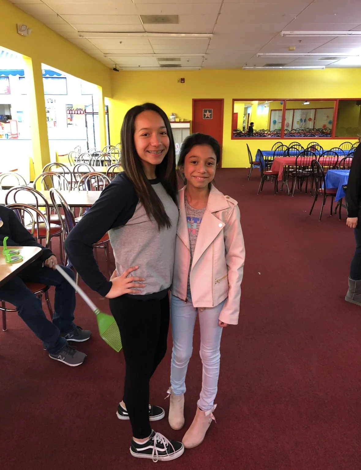 Two girls pose together in the People’s Choice party room in 2018, celebrating a cousin’s first visit to the USA.
