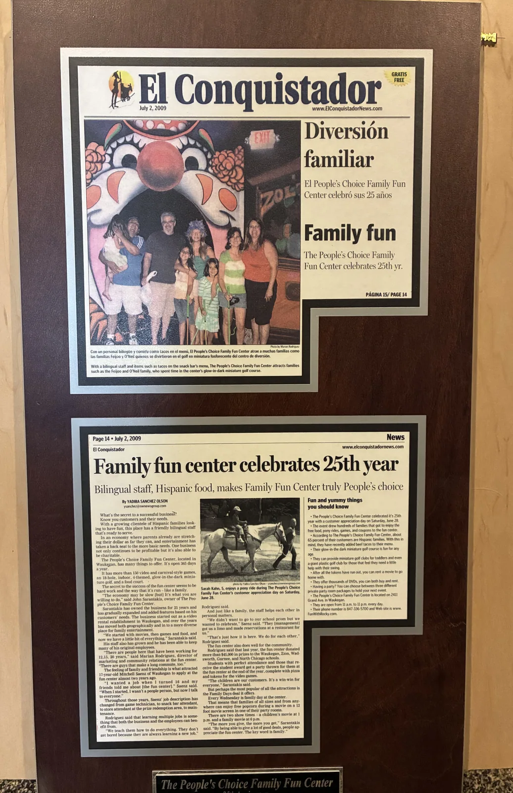Two framed El Conquistador newspaper features from July 2, 2009, including coverage of People’s Choice Family Fun Center’s 25th year.
