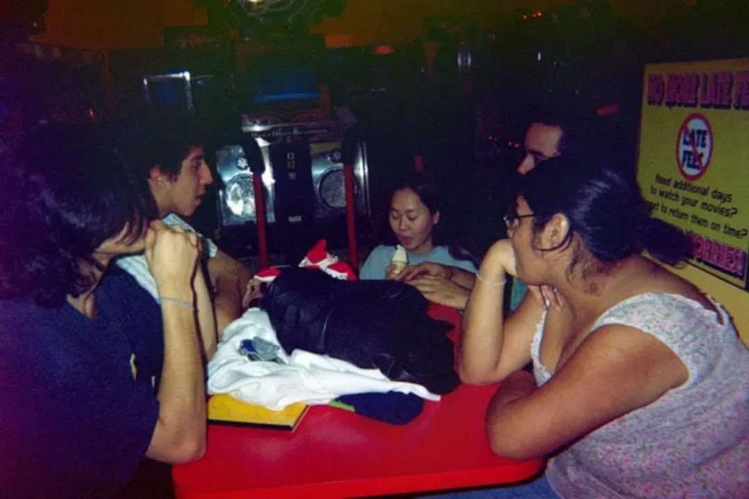 Friends gathered around a red table by the DDR machine at People’s Choice — “Good times at the DDR machine.”