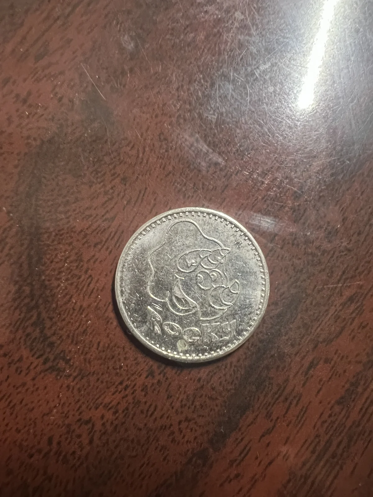 A People’s Choice arcade token stamped with Rocky the dragon, kept from a first visit to the arcade — shared by Ethan Huang.